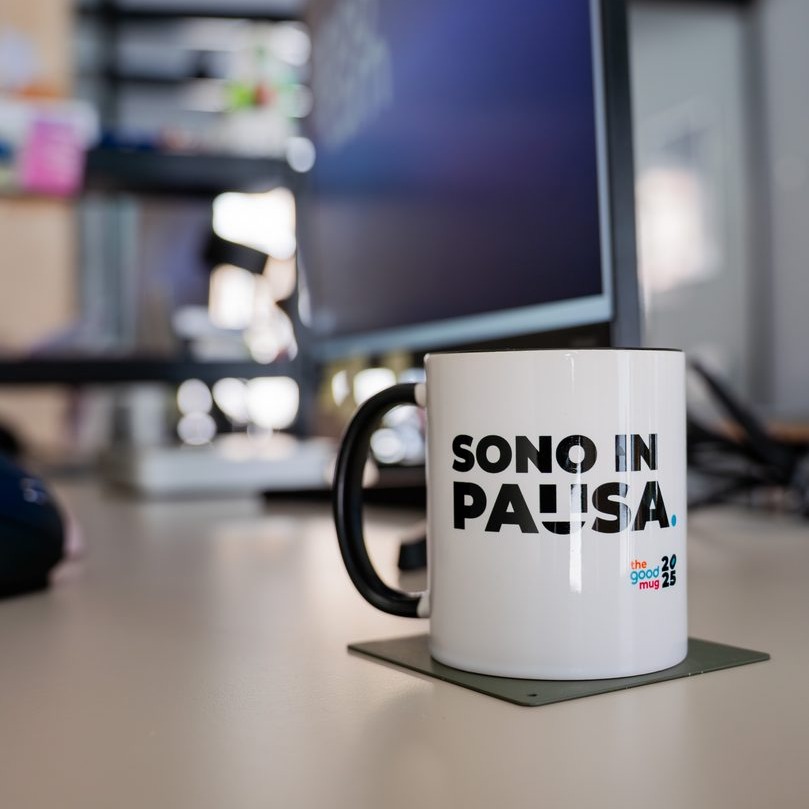 Tazza con la scritta Sono in pausa su una scrivania dello studio GOODCOM