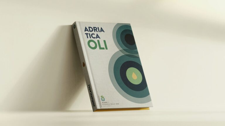 Libro fotografico per i 40 anni di Adriatica Oli appoggiato a una parete