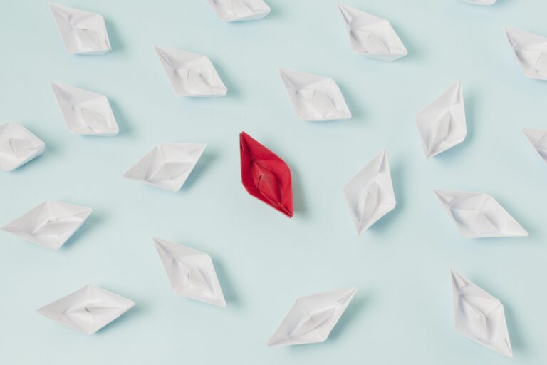 Barchetta di carta rossa tra barchette bianche, simbolo del brand purpose