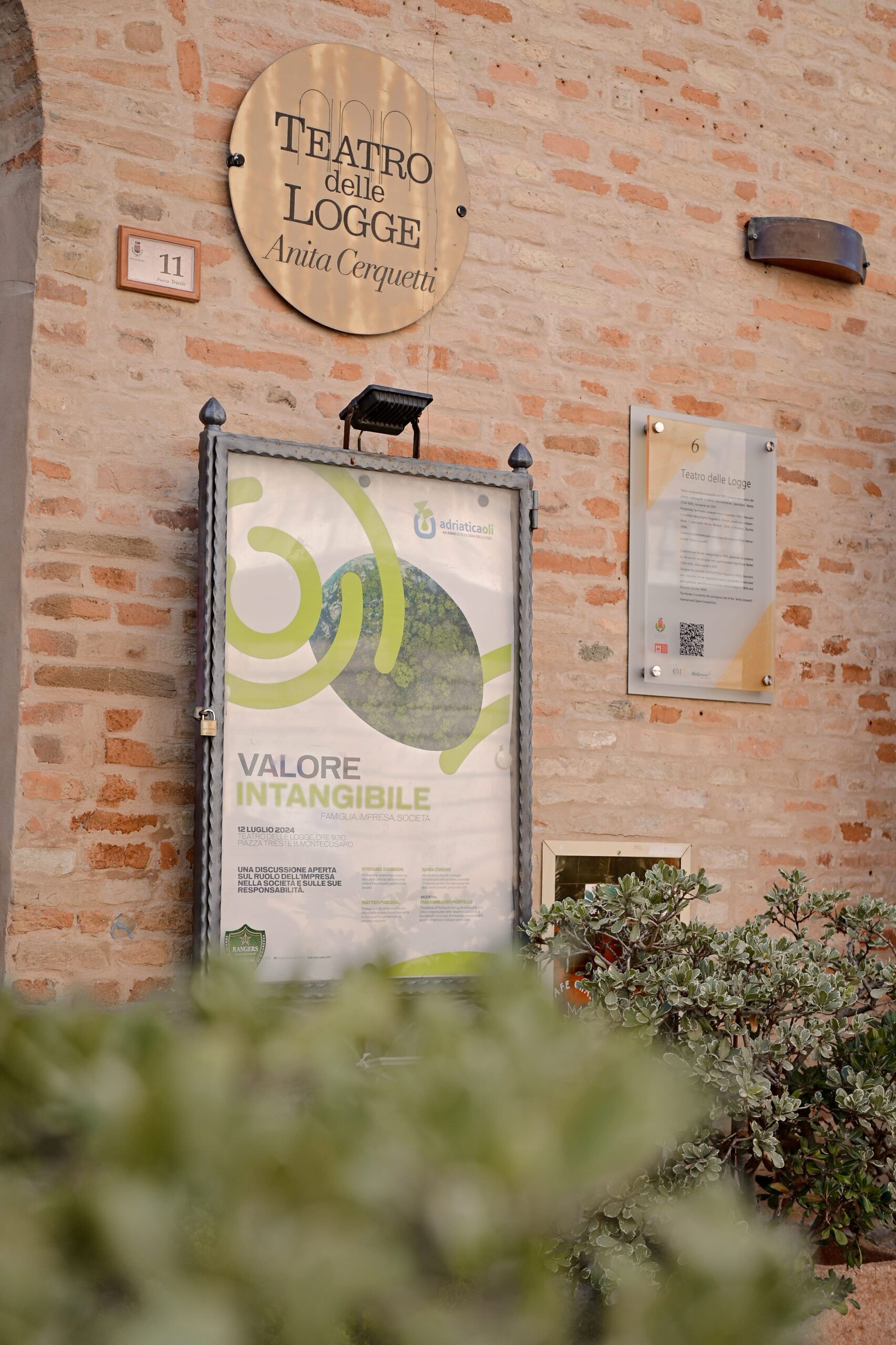 La locandina del convegno all’ingresso del teatro
