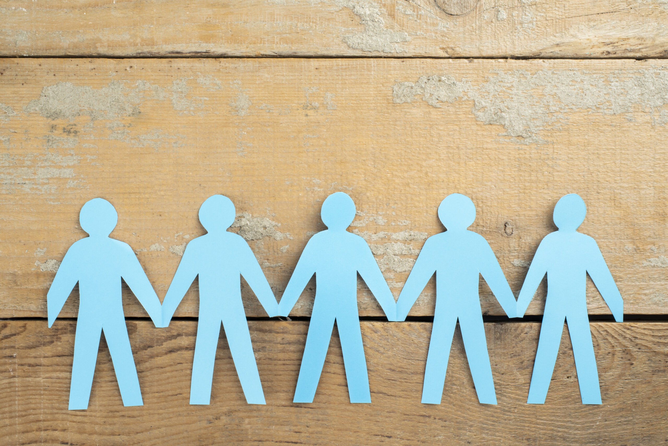 Sagome di persone in carta che si tengono per mano, simbolo della società benefit