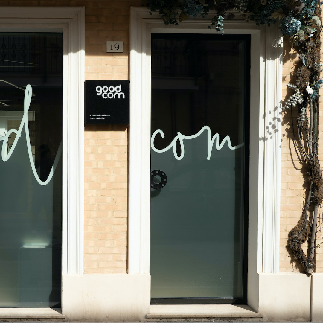 Ingresso dello studio GOODCOM con la scritta com sulla porta a vetri