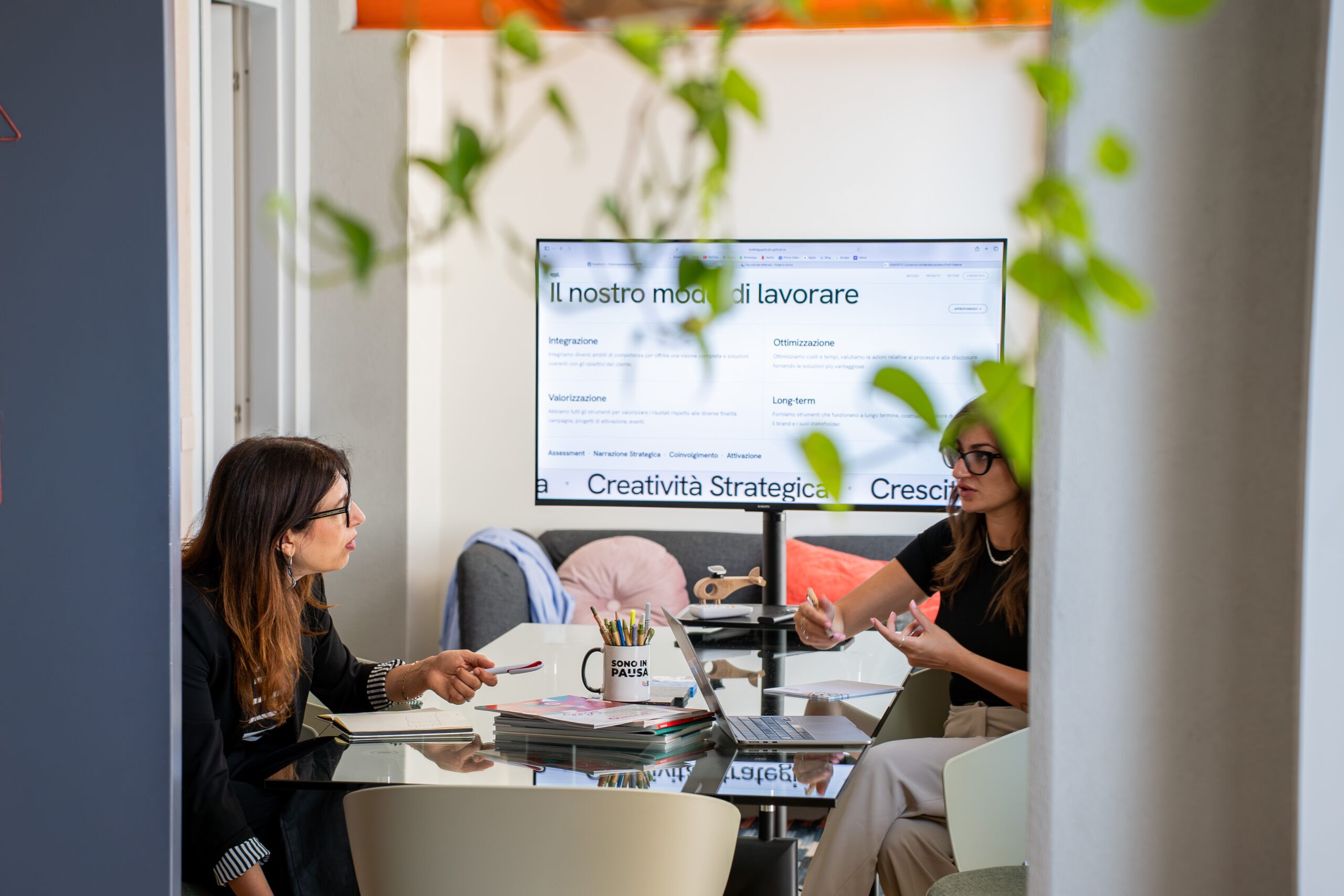 Riunione di strategia di sostenibilità nello studio GOODCOM davanti allo schermo con il metodo di lavoro