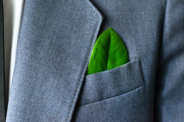Foglia verde nel taschino di una giacca, simbolo della società benefit