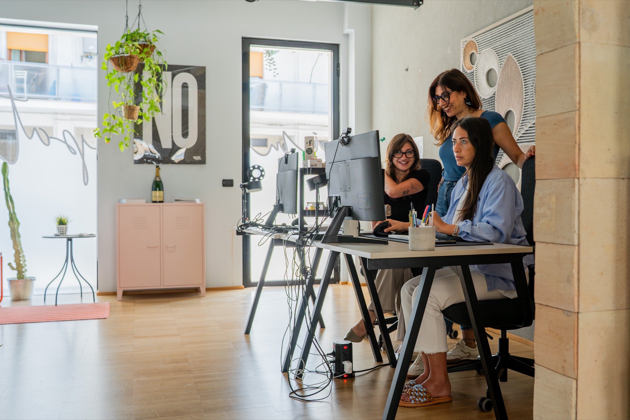 Tre persone del team GOODCOM lavorano al computer nello studio di comunicazione ESG